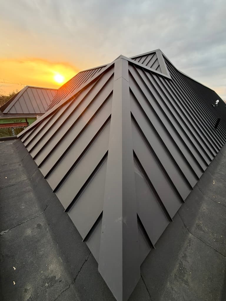 Standing seam ridge detail at sunset — VAH Construction